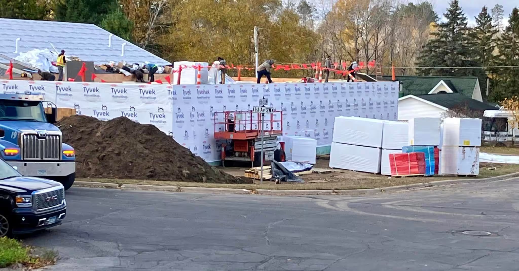 Crews raising wrapped walls during the Grace House expansion